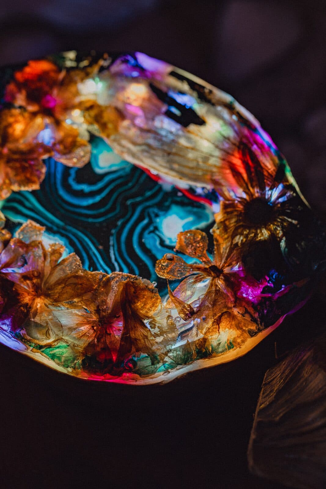Glowing Eluztres lamp with preserved flowers around a blue agate centre