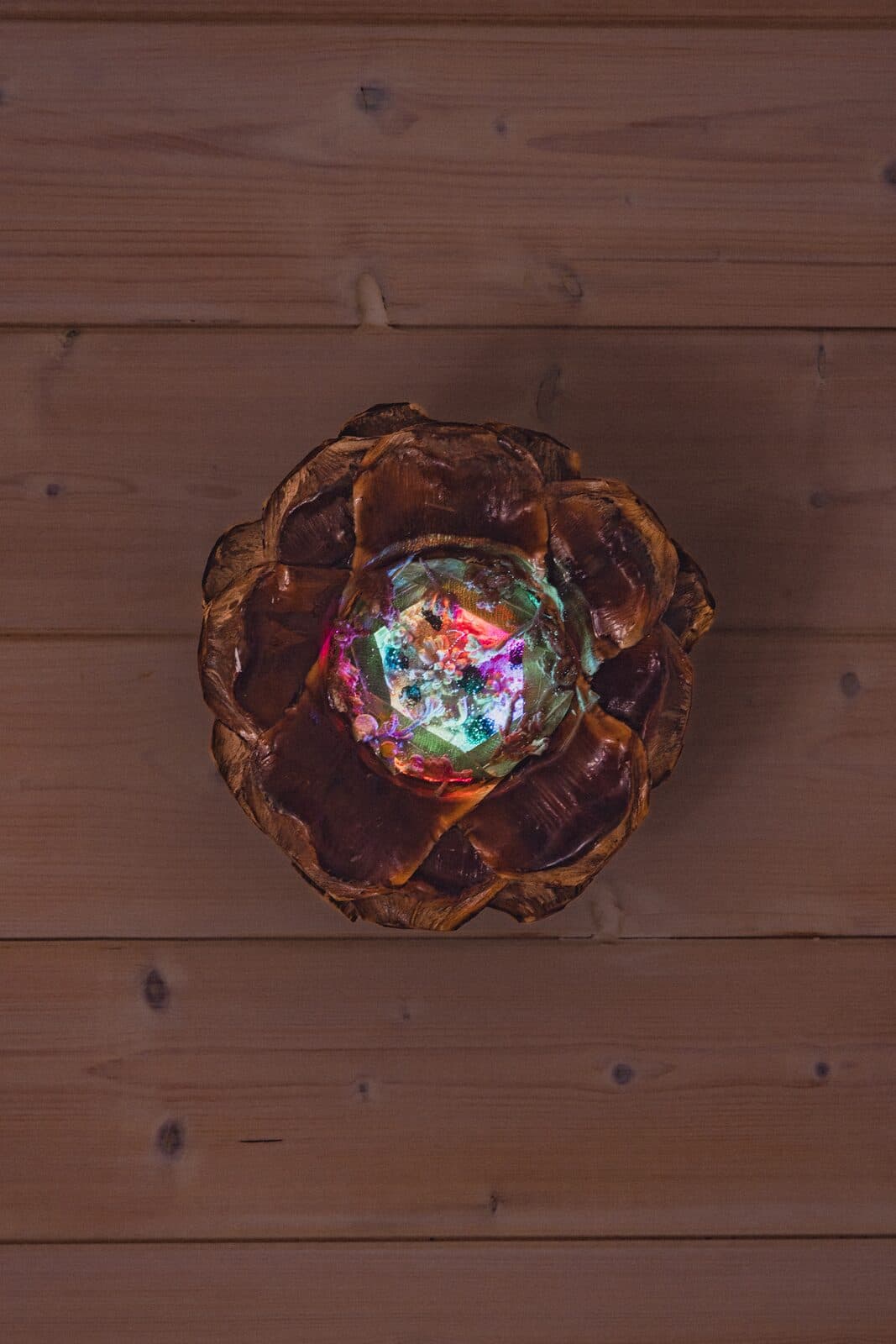 An Eluztres lamp glowing on a wooden floor