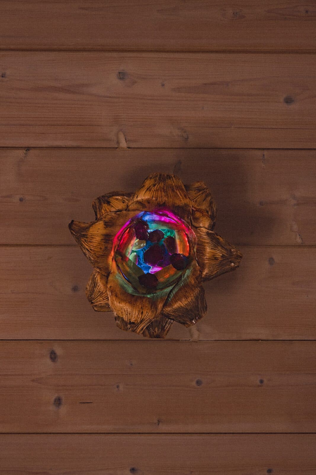 An Eluztres lamp glowing on a wooden floor