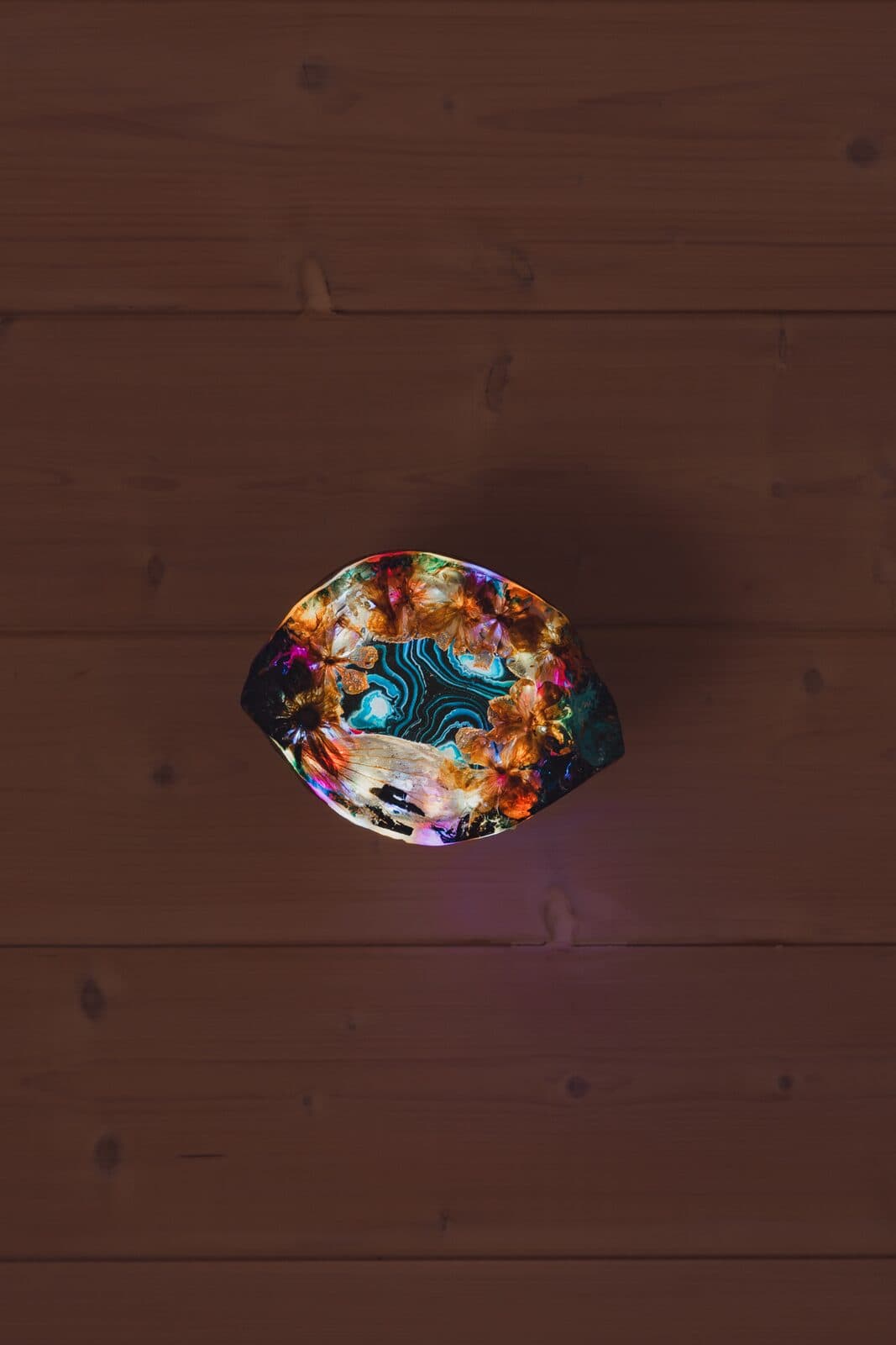 An Eluztres lamp glowing on a wooden floor